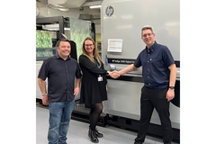 Image HP and Sirane employees shaking hands with HP press in the background.